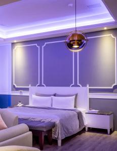 杨梅风阁时尚精品旅馆 的一间卧室配有一张蓝色墙壁的床
