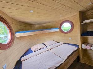 森图尔Glamping Rajska vas的小房间设有一张小床,设有两个窗户