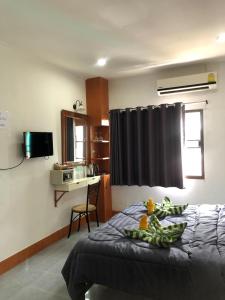 卡伦海滩KANWARA MASSAGE APARTMENT的一间卧室配有一张带黑色窗帘的床和一张书桌