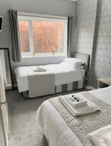 斯凯格内斯The Cresswell Inn的一间卧室设有两张床和窗户。