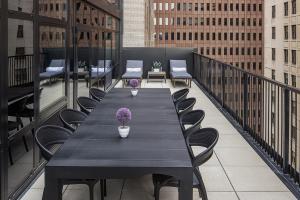 纽约The FIDI Hotel的阳台上配有一张黑色的桌子和椅子