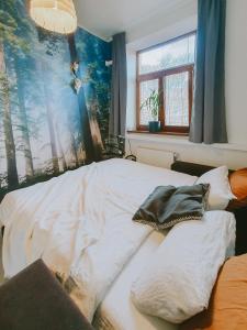 科希策Priestranný apartmán v centre的卧室里的一张未铺好的床,墙上挂着一幅画