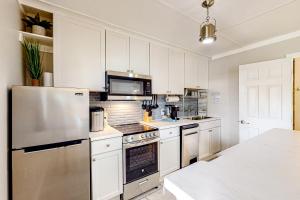 彭萨科拉7213 Flood Reef - Unit 2的厨房配有白色橱柜和不锈钢冰箱