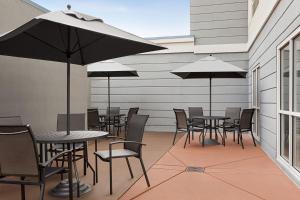 阿马里洛万豪阿马里洛机场费尔菲尔德套房酒店的一个带桌椅和遮阳伞的庭院