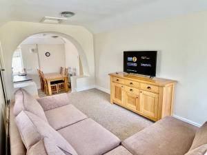 特雷杜尔Bay View Apartment - Trearddur Bay的带沙发和平面电视的客厅
