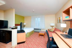 布卢明顿TownePlace Suites by Marriott Bloomington的酒店客房设有一间带一张床和一张书桌的卧室