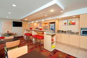 布卢明顿TownePlace Suites by Marriott Bloomington的一间大厨房,里面设有红色的酒吧凳子