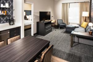 拉斯维加斯Residence Inn Las Vegas South/Henderson的酒店客房设有带沙发和桌子的客厅。