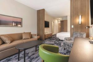 肖尼Fairfield Inn & Suites by Marriott Kansas City Shawnee的酒店客房设有一张沙发和一张床