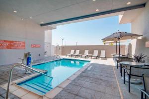 沃思堡TownePlace Suites Fort Worth University Area/Medical Center的大楼内一个带桌椅的游泳池