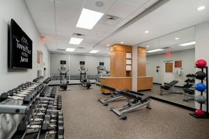 沃思堡TownePlace Suites Fort Worth University Area/Medical Center的健身房,有几排健身自行车和举重器材