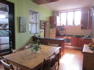 开普敦Victorian Woodstock的一间带木桌的厨房和一间餐厅
