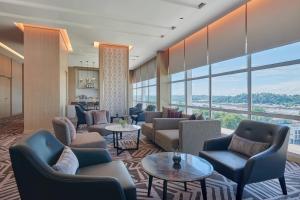 民都鲁Fairfield by Marriott Bintulu Paragon的酒店大堂设有长沙发、桌子和大窗户。