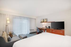 伯明翰伯明翰霍姆伍德万怡酒店的酒店客房配有一张床、一张书桌和一台电视。