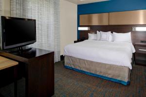 比奇伍德Residence Inn by Marriott Cleveland Beachwood的配有一张床和一台平面电视的酒店客房