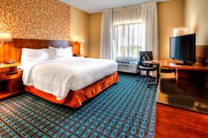 育空俄克拉荷马市育空费尔菲尔德套房酒店的配有一张床和一台平面电视的酒店客房