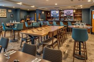 安克雷奇Four Points by Sheraton Anchorage Downtown的餐厅设有木桌和蓝色椅子