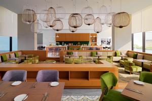 迪拜Element Me'aisam, Dubai的餐厅设有木桌和绿色椅子