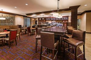 奥德萨敖德萨万豪万怡酒店的餐厅设有酒吧和桌椅
