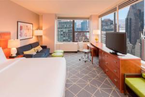 纽约纽约曼哈顿/市中心东区庭院酒店的一间酒店客房,配有一张床和一台电视