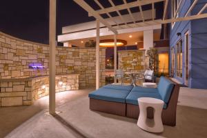 休斯顿休斯顿I-45北春季山丘套房万豪酒店的一个带蓝色沙发和石墙的庭院