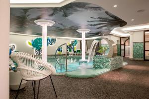 德累斯顿德雷斯顿品牌系列酒店的酒店大堂的水滑梯,配有两把椅子