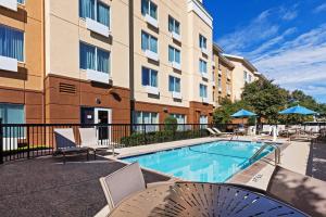 奥斯汀奥斯汀西北/域区费尔菲尔德万豪套房酒店的一座带椅子的游泳池以及一座建筑