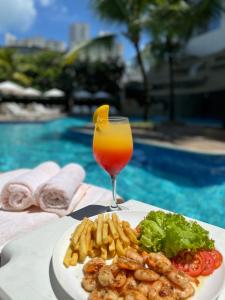累西腓马尔约定酒店的池边的一大盘食物和饮料