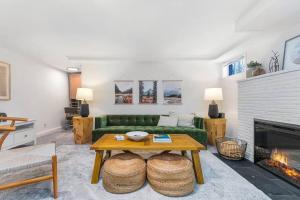 西雅图Lilac In Law, Picturesque lower unit的客厅设有绿色沙发和壁炉