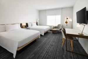 普兰特城TownePlace Suites by Marriott Plant City的酒店客房配有两张床和一张书桌