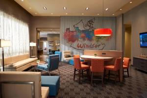 温莎温莎优质套房酒店的大堂设有带桌椅的用餐区。