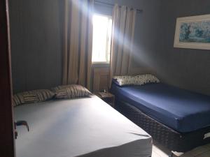 圣洛伦索Cantinho do Rafa的一间卧室设有两张床和窗户。