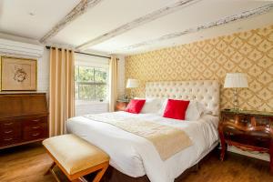 伊泰帕瓦Su Paradise Chalés e Suítes的卧室配有带红色枕头的大型白色床