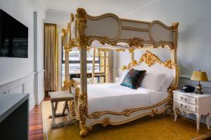 新加坡克莱尔蒙特酒店的一间卧室配有金色天蓬床和椅子