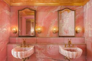 新加坡克莱尔蒙特酒店的粉红色浴室内的2个水槽和2个镜子