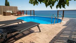 KhartátaZante Xigia Bay villas的一个带桌椅的海洋游泳池