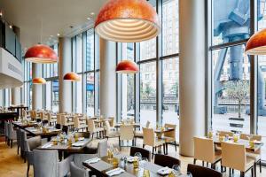 伦敦Marriott Executive Apartments London, Canary Wharf的餐厅设有桌椅和大窗户。