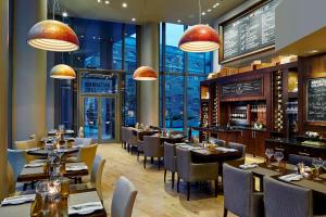 伦敦Marriott Executive Apartments London, Canary Wharf的一间带桌椅的餐厅和一间酒吧