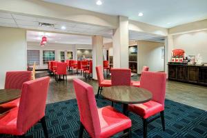 圣安东尼奥圣安东尼奥西北万豪广场套房酒店的一间设有红色桌椅的餐厅和一间酒吧