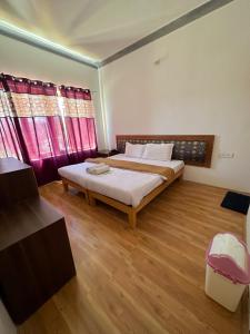 列城Zeejeed palace的一间卧室设有一张大床,铺有木地板。