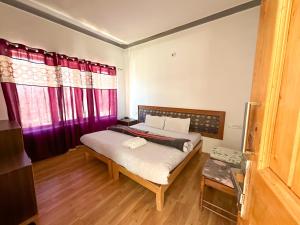 列城Zeejeed palace的一间卧室配有一张带红色窗帘的大床