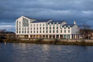 因弗内斯AC Hotel by Marriott Inverness的水体旁的白色大建筑