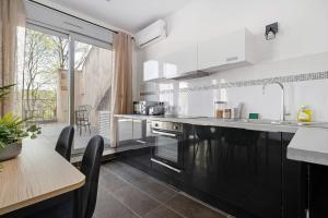 卡威尔奎Lyon Cité-Gallo Romaine terrasse的厨房配有黑白电器和桌子
