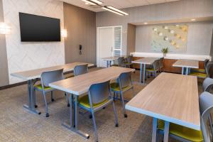 森林湖SpringHill Suites by Marriott Irvine Lake Forest的一个带桌椅和平面电视的教室