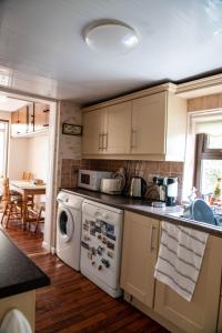 巴利海吉Sheila's Cottage Ballyheigue的一个带水槽和洗碗机的厨房