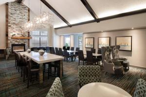 杰克逊维尔Residence Inn by Marriott Jacksonville Butler Boulevard的一间带桌椅和壁炉的用餐室