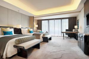 深圳深圳瑞吉酒店的酒店客房配有两张床和一张书桌