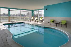 Del CitySpringHill Suites by Marriott Oklahoma City Midwest City Del City的大楼内带桌椅的大型游泳池