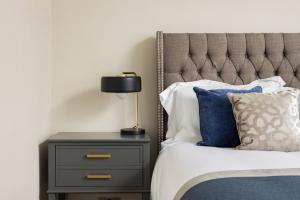 伦敦Avari Apartments - Hatton Collection的一间卧室配有一张床和一个带灯的床头柜
