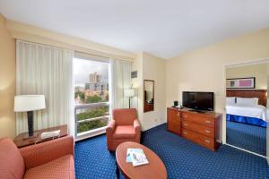 圣胡安圣胡安米拉马尔万怡酒店的酒店客房带一张床、一台电视和椅子